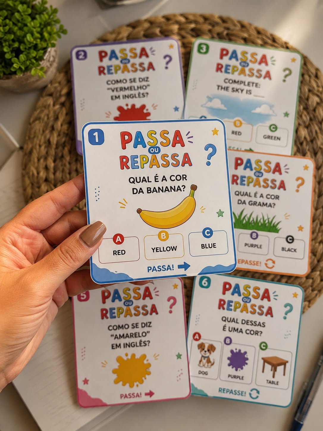 Mão segurando carta do kit Passa ou Repassa Inglês Infantil
